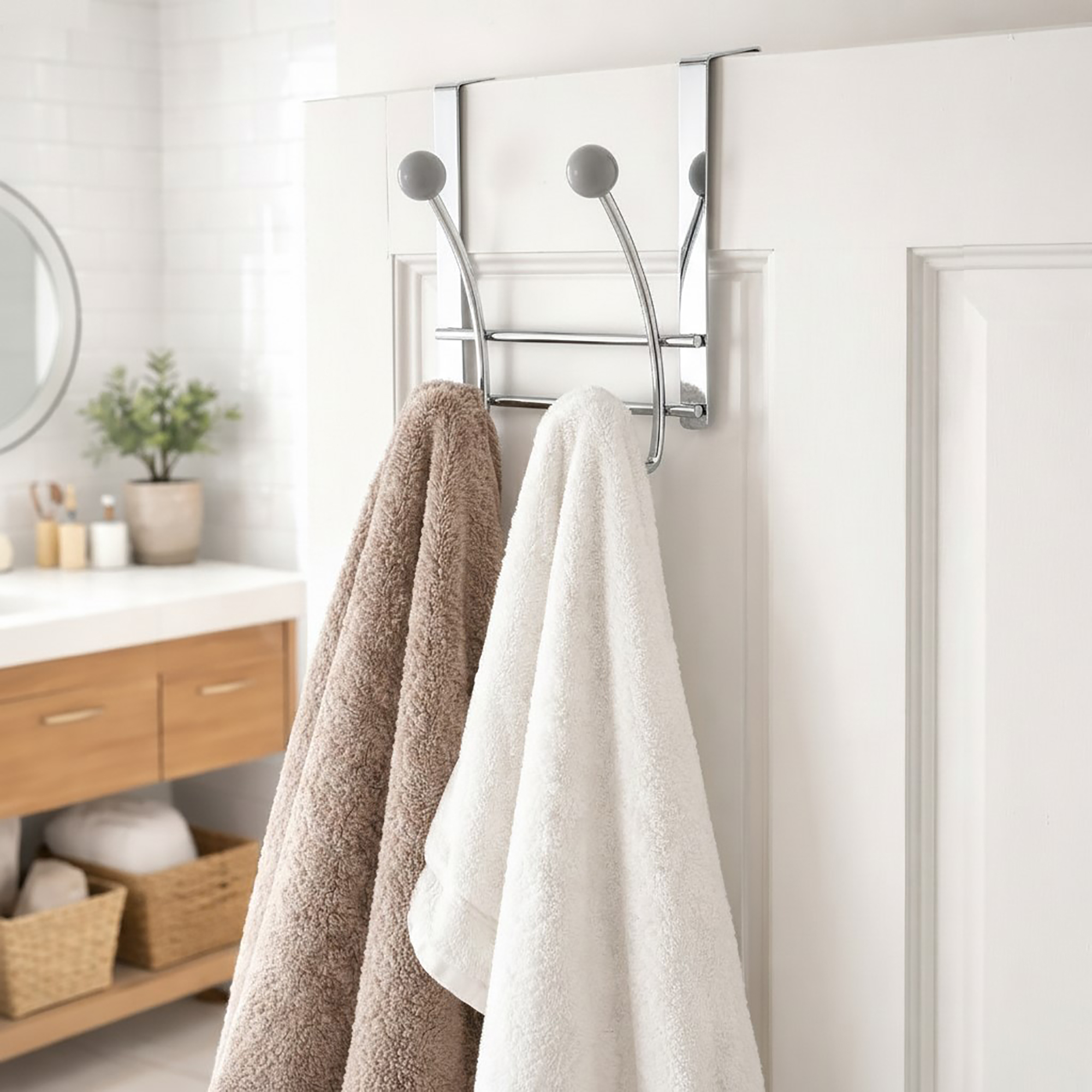 Chrome over-the-door hook rack with 4 gray ball hooks, holding a beige and a white towel on a white bathroom door.