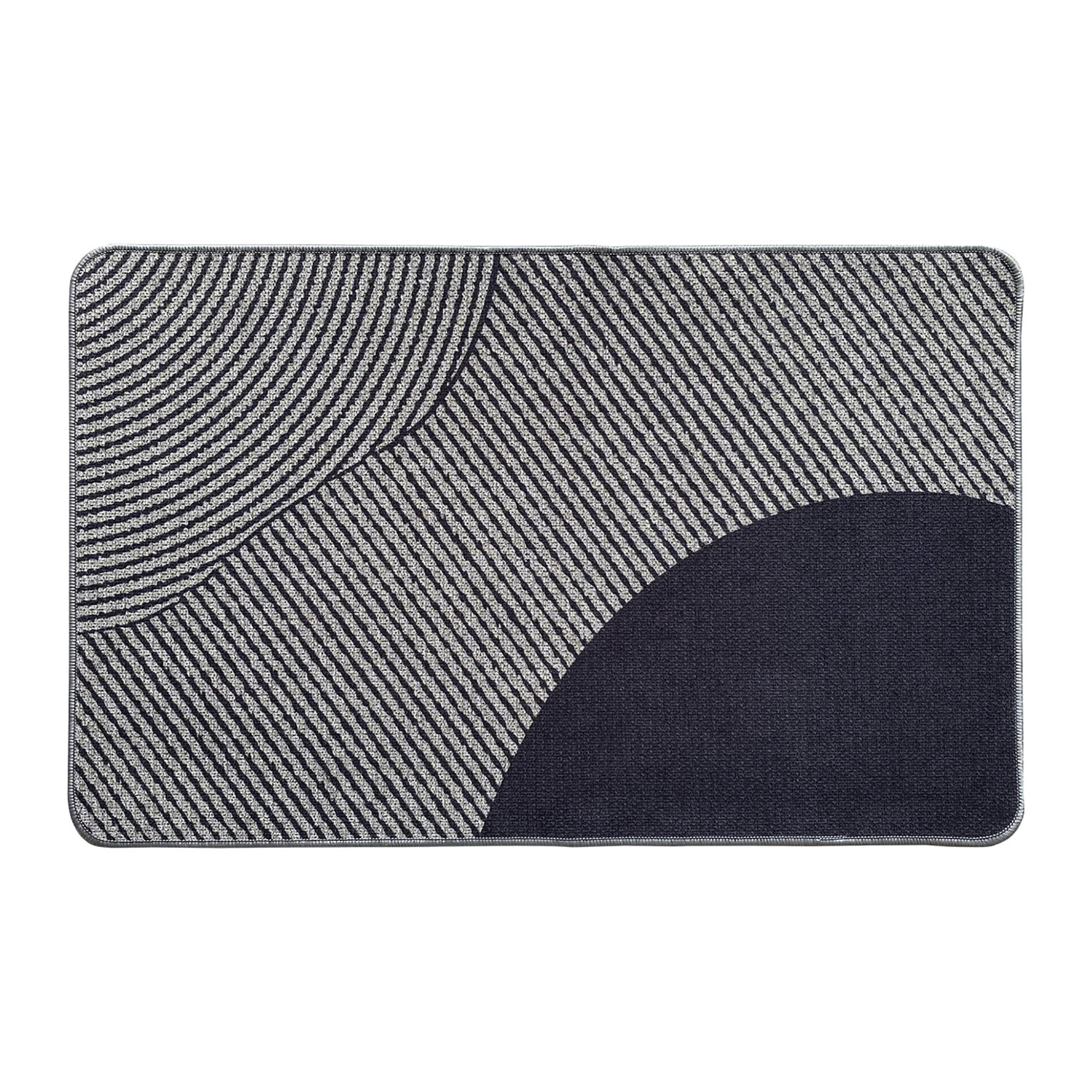 Top view of a geometric gray and black kitchen mat with curved and striped patterns
