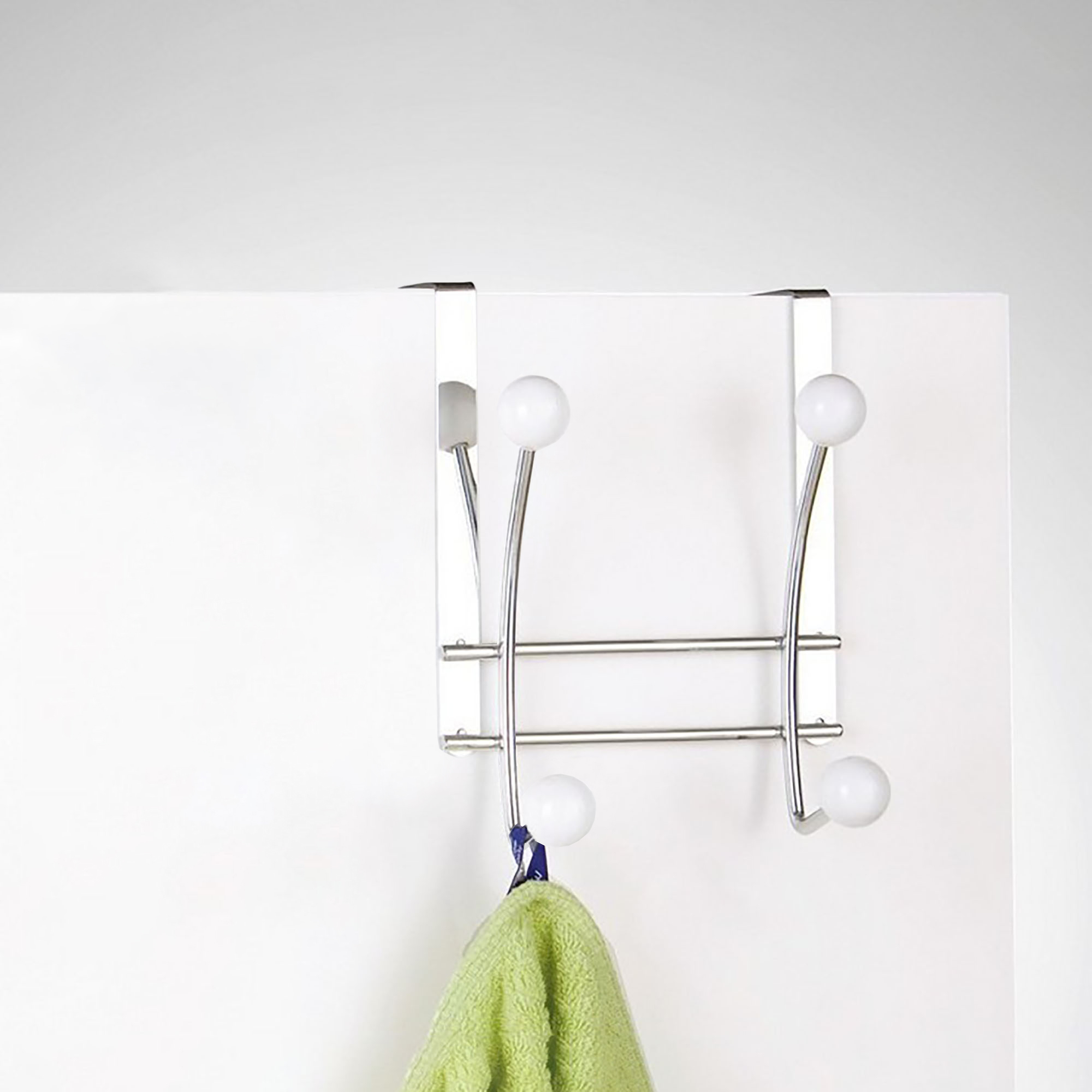 Hook rack on white door holding green towel usage example