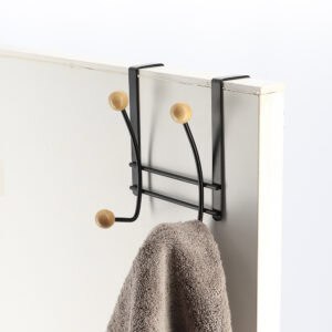 Hook rack on white door holding green towel usage example