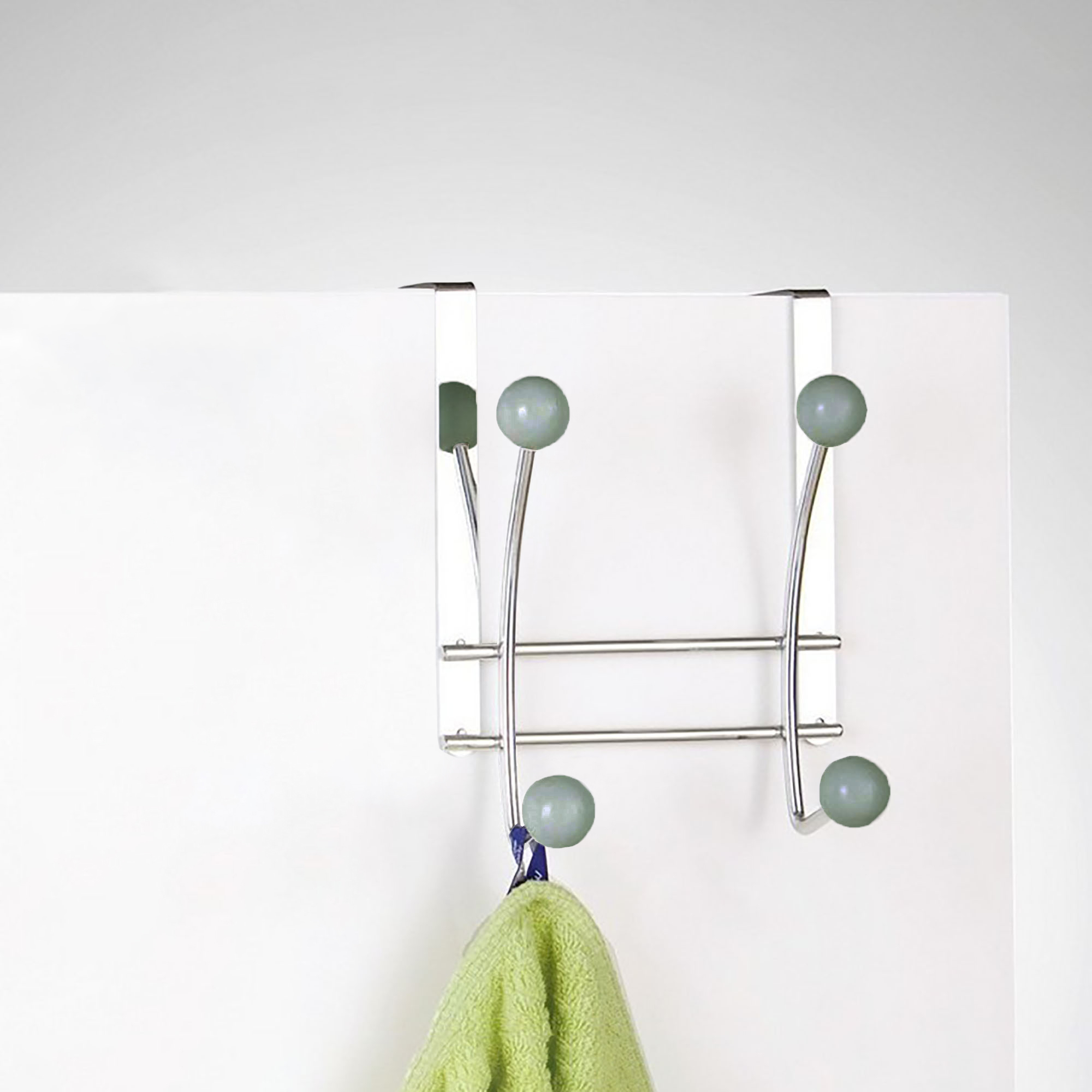 Hook rack on white door holding green towel usage example