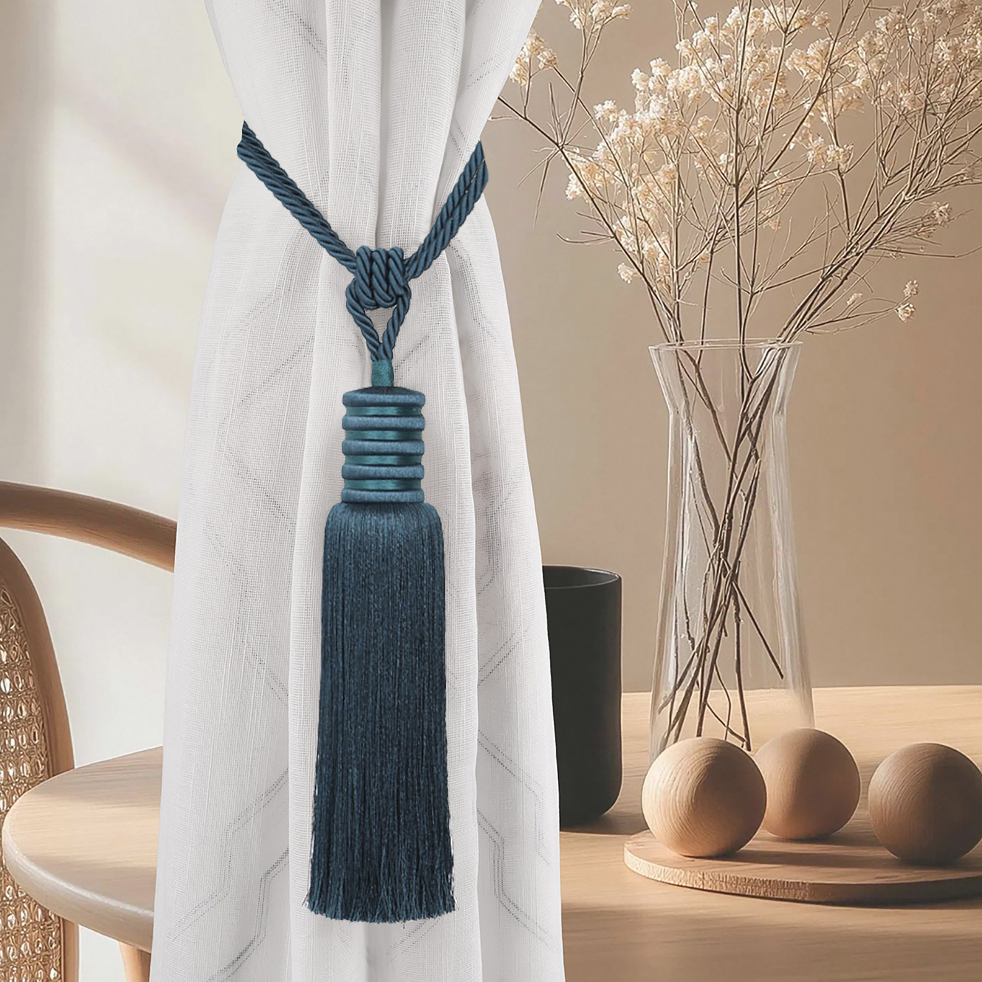 Deep teal curtain tieback elegantly styled on white curtain in modern interior with wood decor and vase