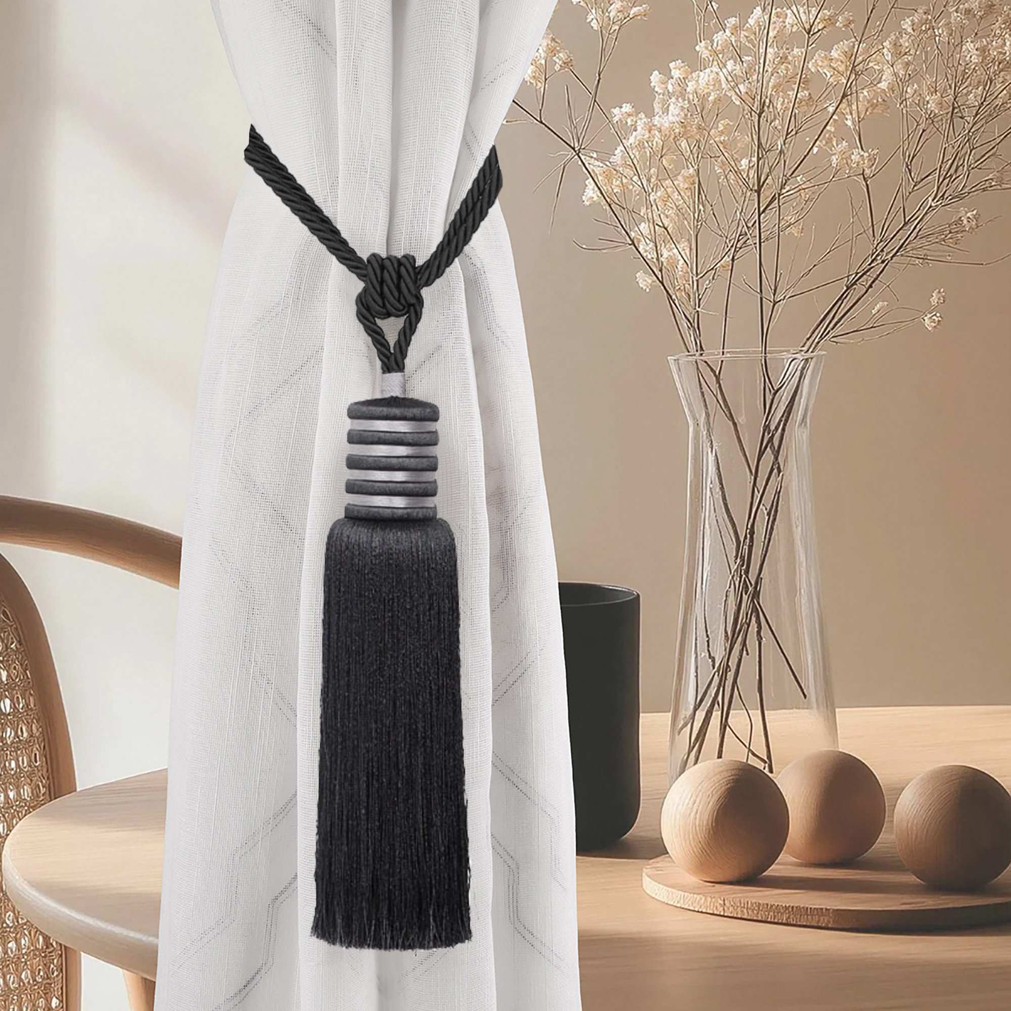 Midnight black tieback styled on light curtain with natural wood decor and vase in cozy interior scene