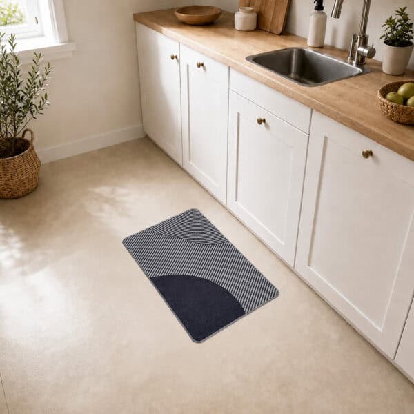 Gray geometric kitchen mat placed on tile floor beside a white sink cabinet, adding modern style to a bright kitchen space.