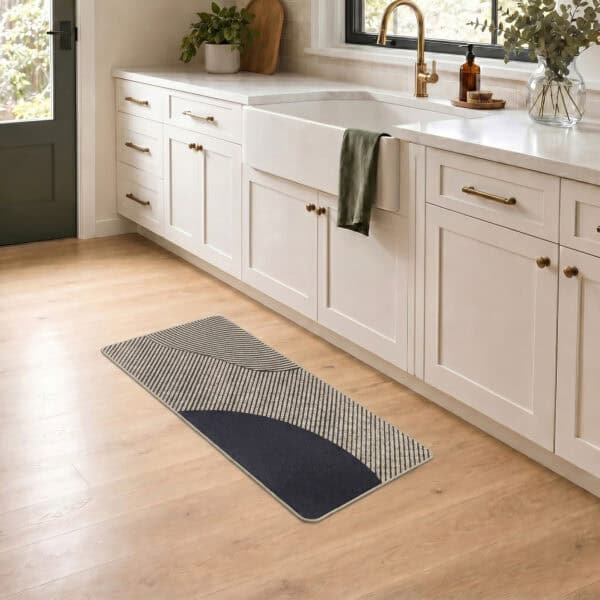 Beige geometric kitchen runner laid along a farmhouse sink cabinet on wood flooring, bringing warm modern style to a bright kitchen.