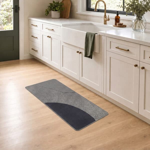 Gray geometric kitchen runner laid along a farmhouse sink cabinet on wood flooring, bringing modern style to a bright kitchen.