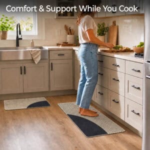 Person standing comfortably on a beige kitchen mat while a matching runner sits nearby, cushioned support for cooking and cleanup tasks.