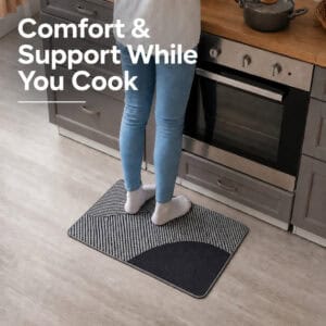 Person standing comfortably on a gray kitchen mat while cooking at the counter, cushioned support that eases pressure during long tasks.