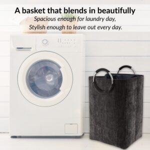 Laundry basket in charcoal gray beside washer in minimalist setup