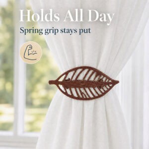 Rustic brown leaf curtain tieback with spring grip holding gathered sheer fabric