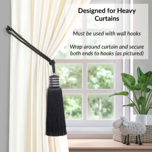 Midnight black curtain tieback wrapped around thick drapes and fastened with wall hooks for secure hold