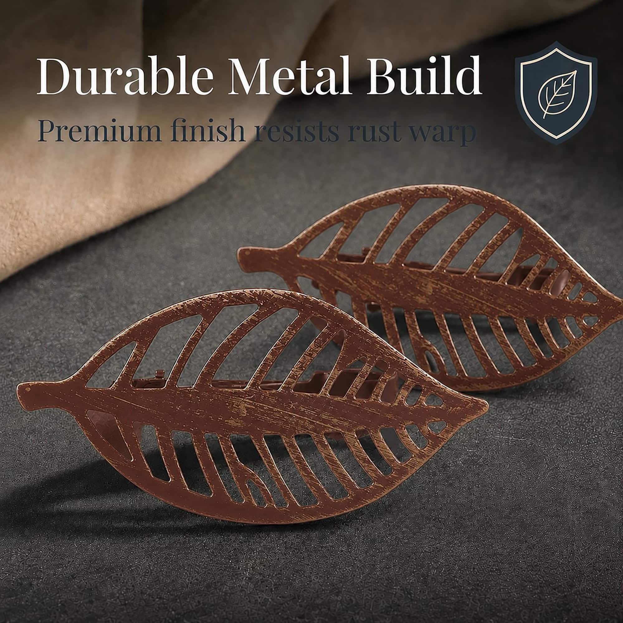 Two rustic brown metal leaf curtain tiebacks shown close up on dark fabric