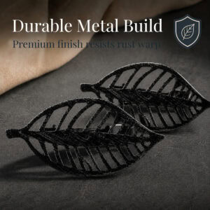 Two textured black metal leaf curtain tiebacks shown close up on dark fabric