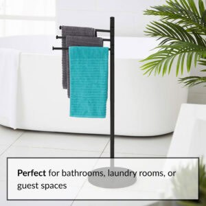 "Black 3-arm swivel towel rack holding gray and teal towels next to freestanding bathtub"