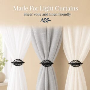 Textured black leaf curtain tiebacks on white, gray, and ivory sheer panels