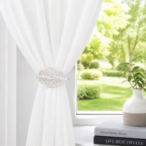Whitewash leaf curtain tieback on a white sheer panel by a sunny window with a vase