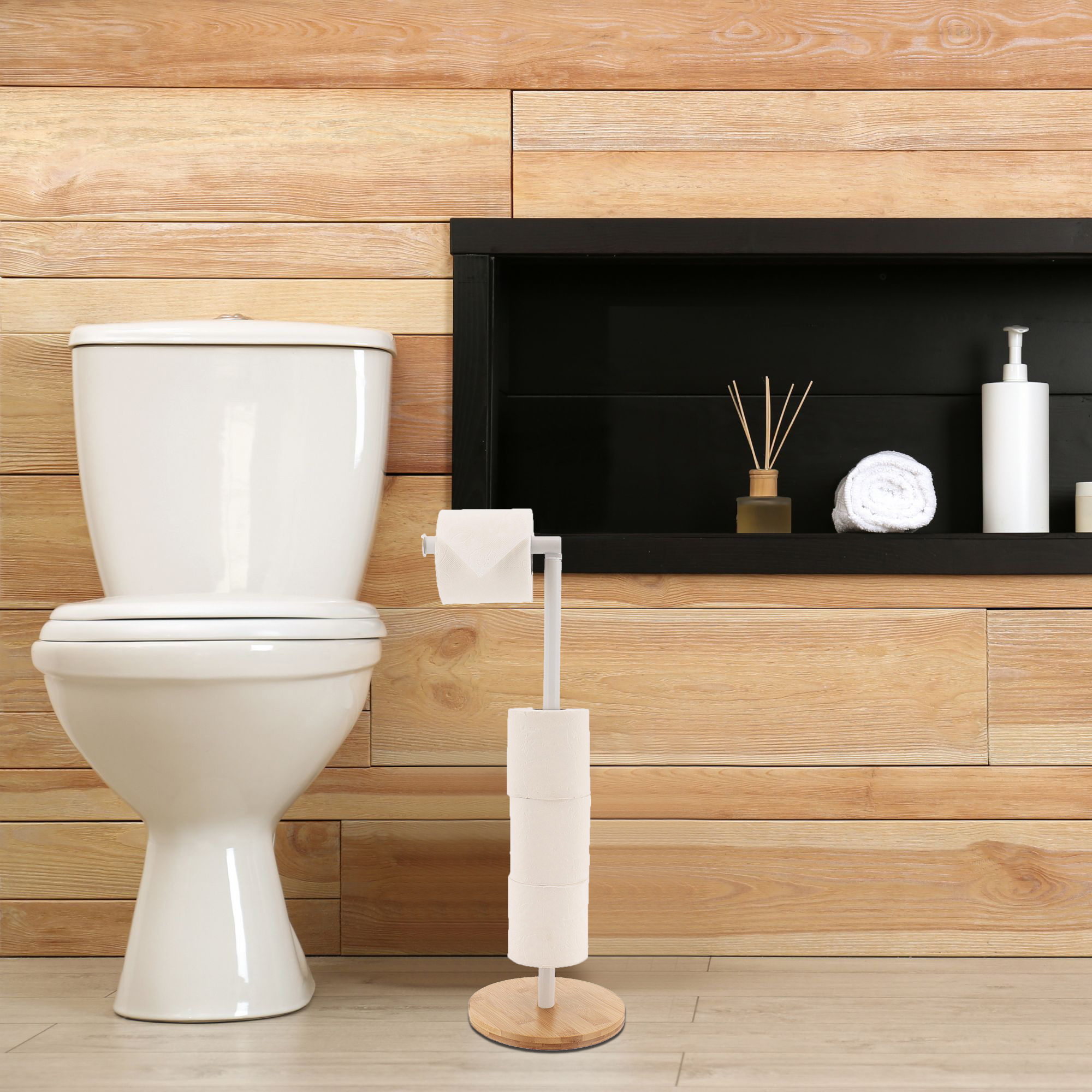 White toilet paper holder with bamboo base next to toilet in bathroom