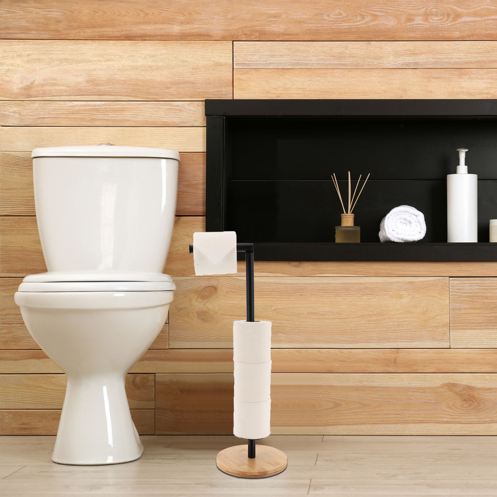 Black toilet paper holder with bamboo base next to toilet in bathroom