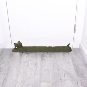 Dog draft stopper placed at the bottom of a closed white door on a gray wood floor