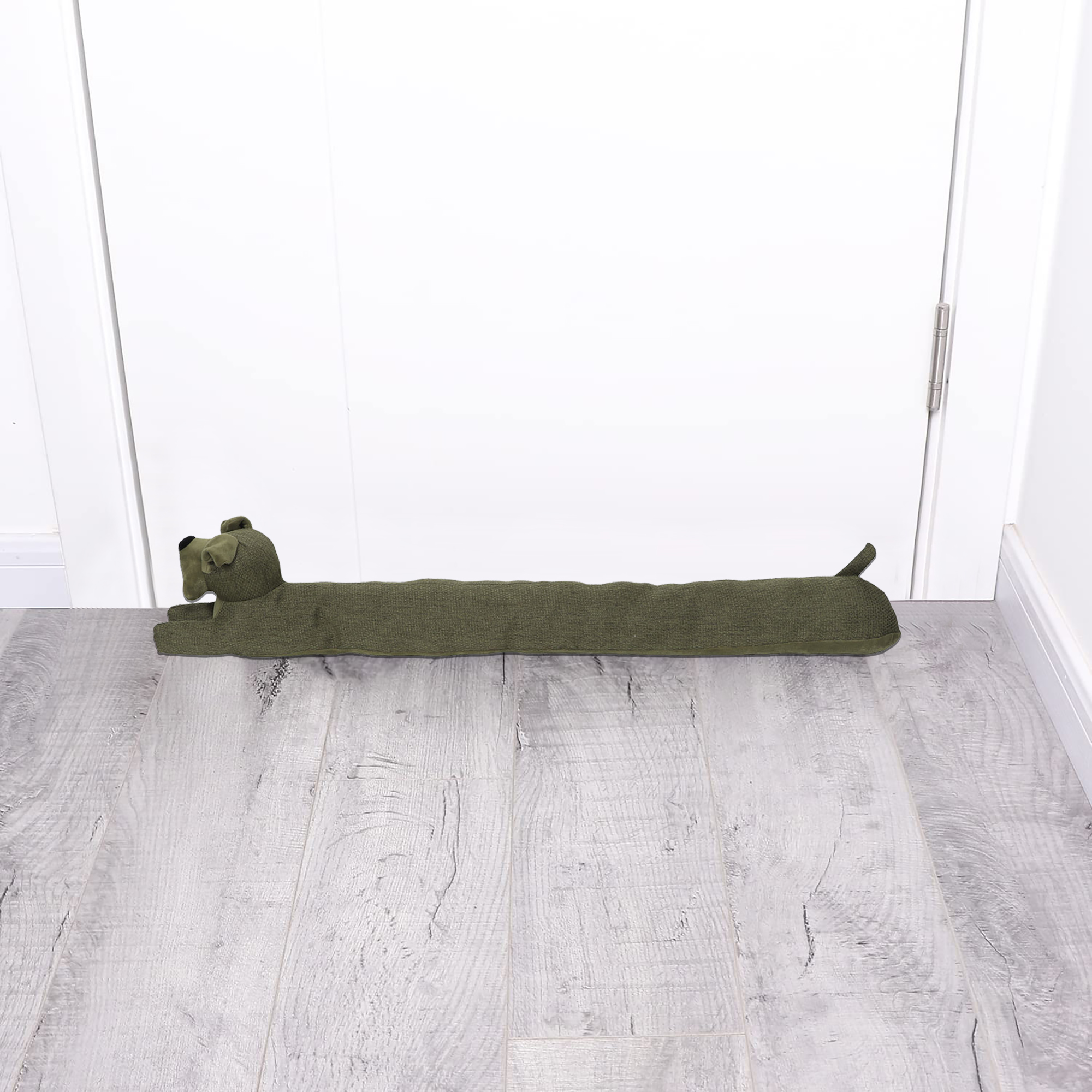 Dog draft stopper placed at the bottom of a closed white door on a gray wood floor