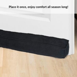 Draft stopper positioned snugly at door corner on light wooden floor for effective insulation