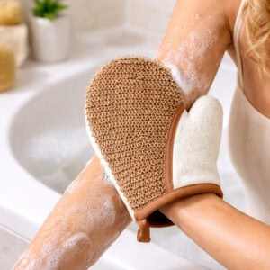 Person using exfoliating mitt to scrub soapy leg in bathtub