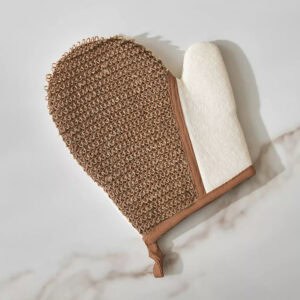 Close-up view of exfoliating mitt showing textured brown surface and white terry interior