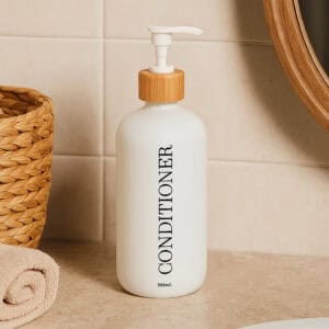 White conditioner bottle on bathroom counter with towels and basket