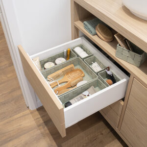 Sage green drawer organizers arranged neatly in bathroom drawer