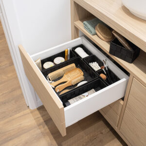 Black drawer organizers neatly arranged in bathroom drawer