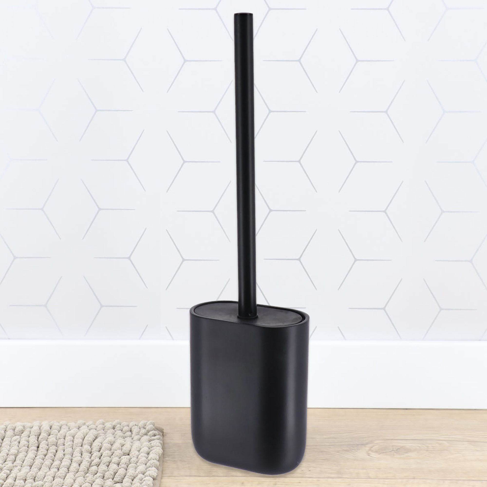 Black toilet brush holder on bathroom floor