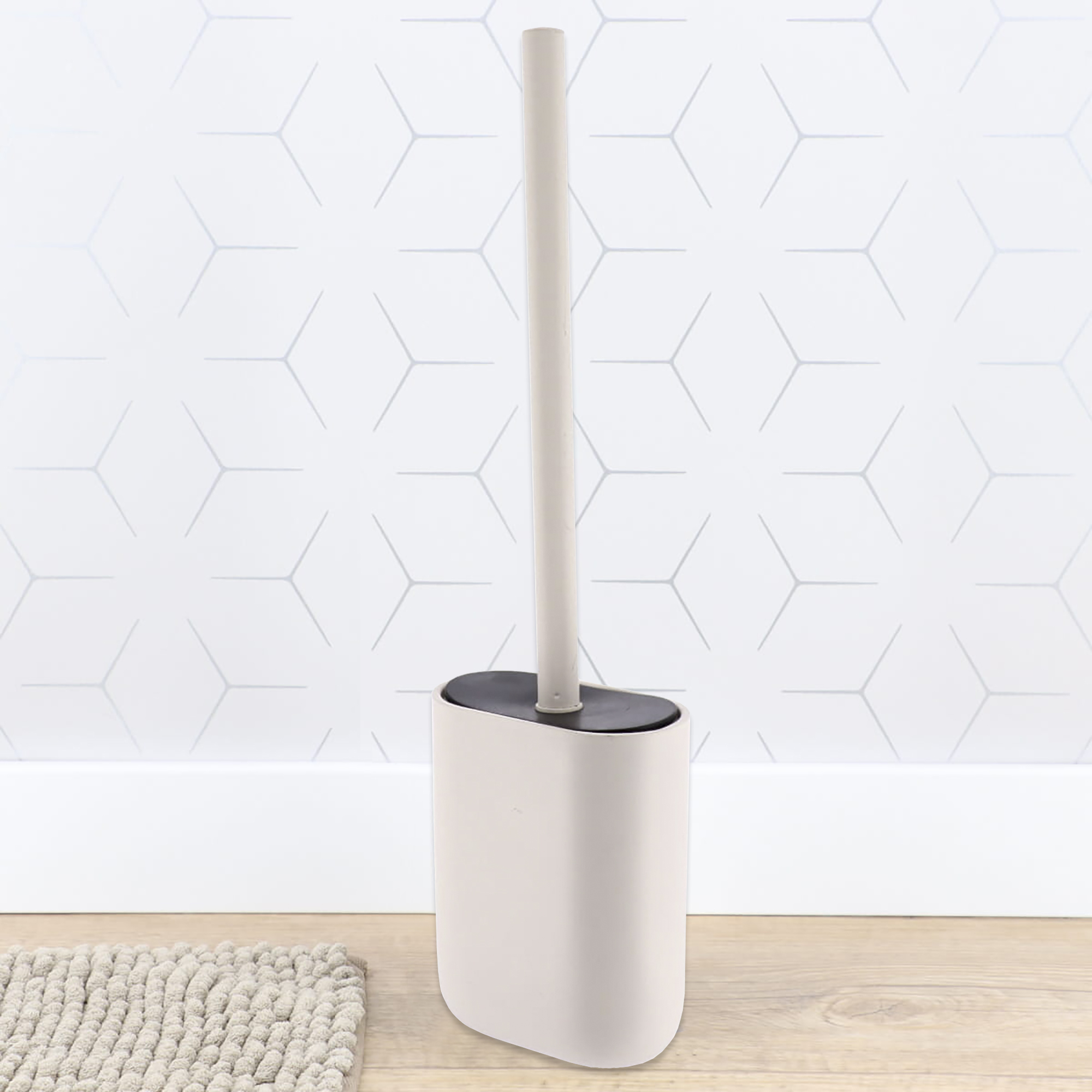 Beige toilet brush holder on bathroom floor