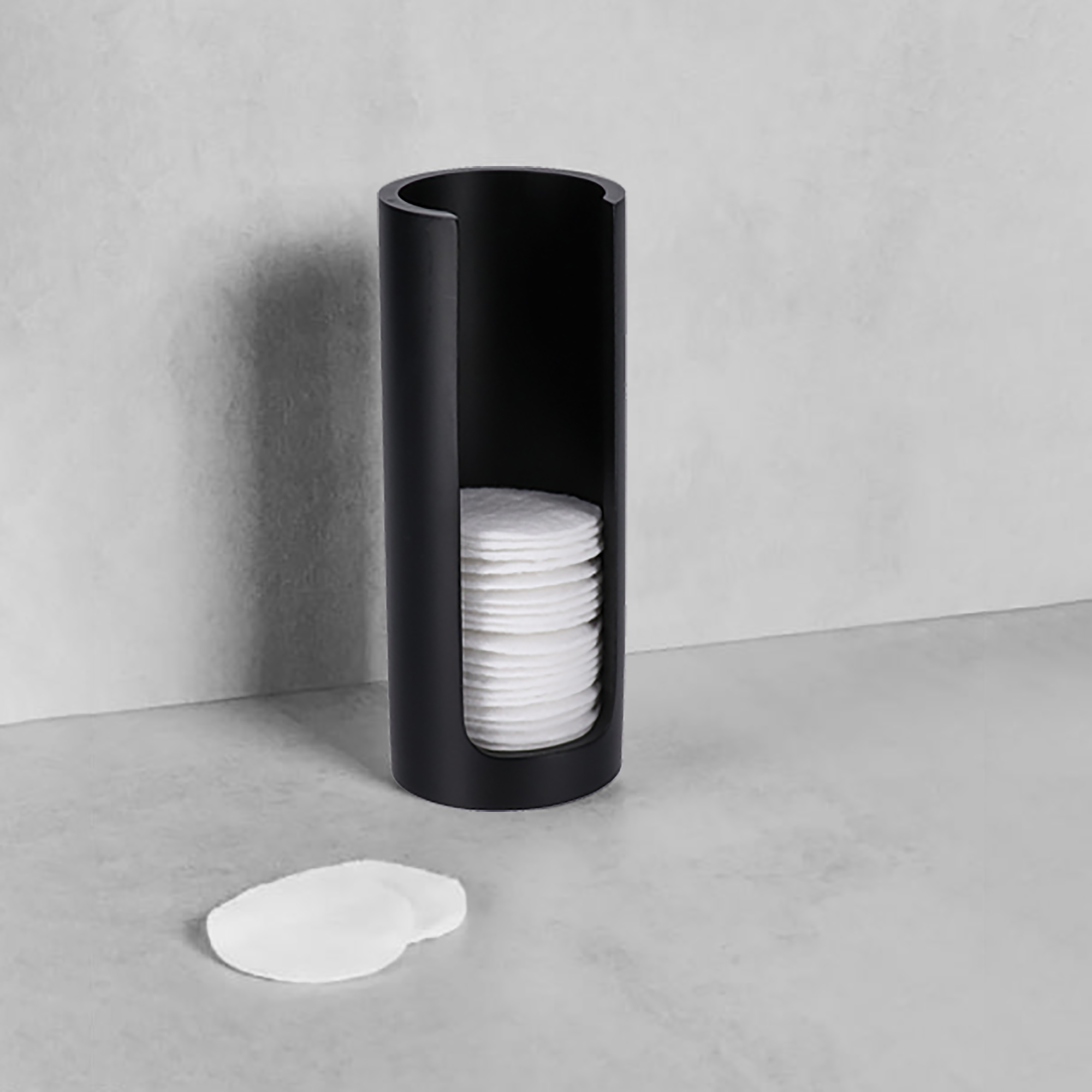 Black cotton pad holder with pads on counter