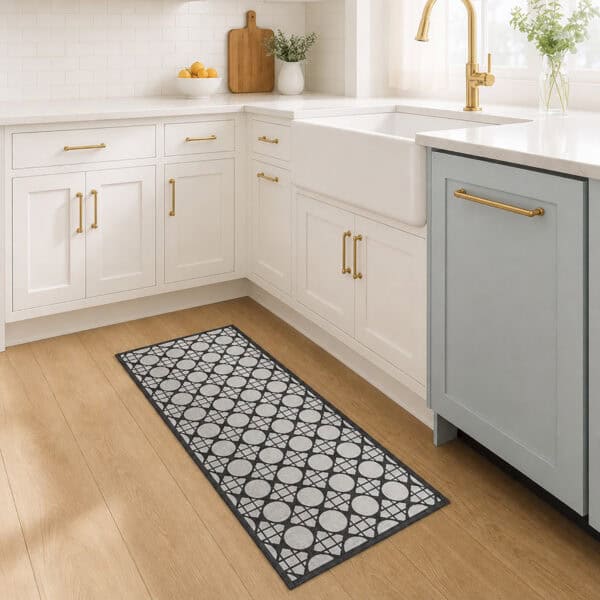 2- Cream and charcoal cane circle kitchen runner on wood floor in front of a white farmhouse sink