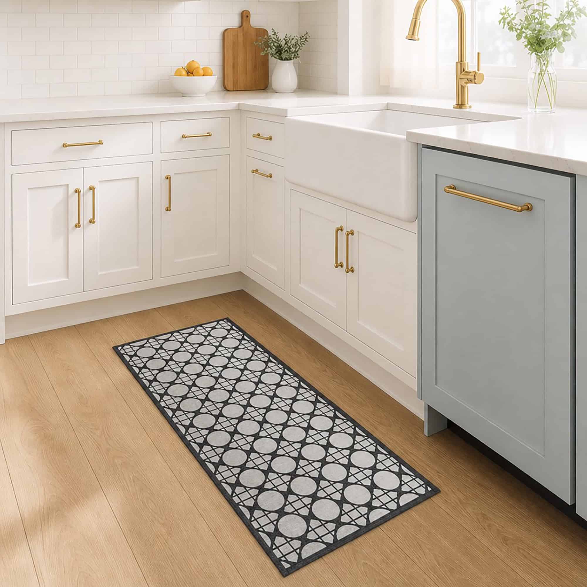 2- Cream and charcoal cane circle kitchen runner on wood floor in front of a white farmhouse sink