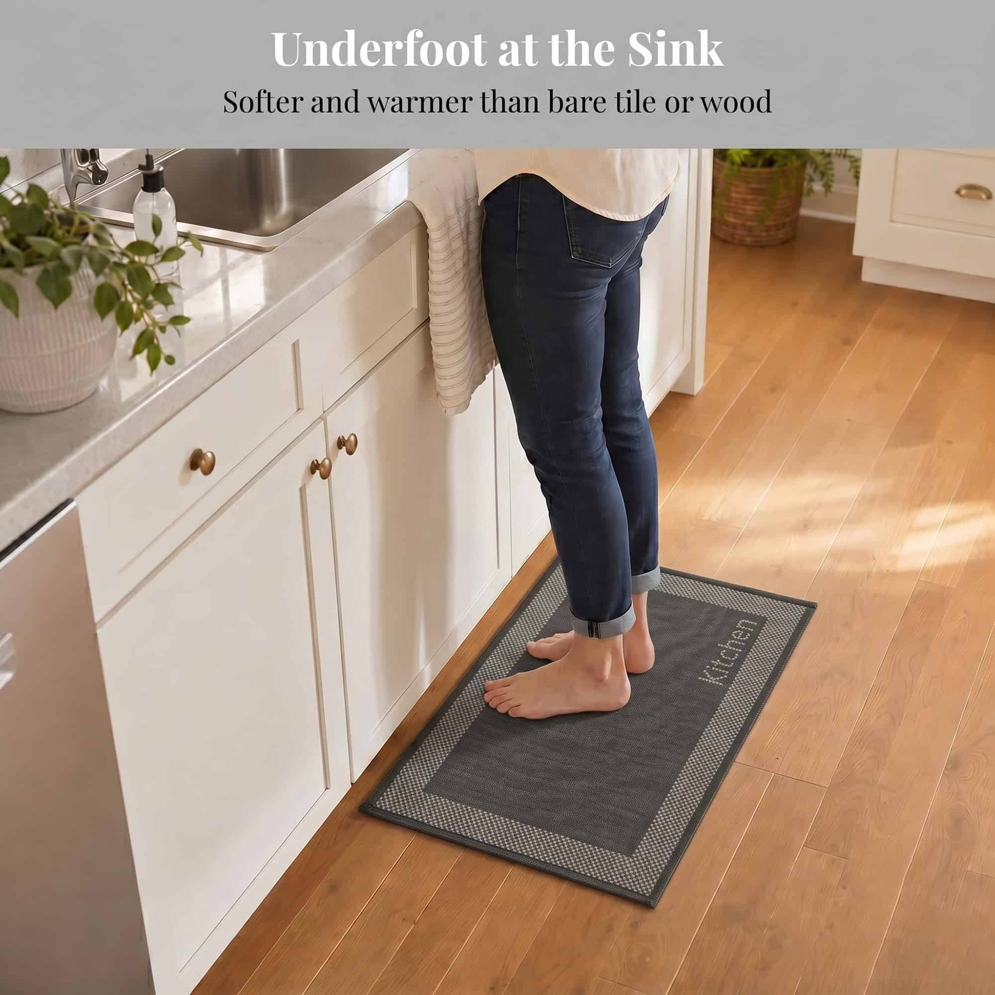 3- Barefoot person standing on charcoal kitchen mat with cream border at the sink, cushioned on hardwood floor