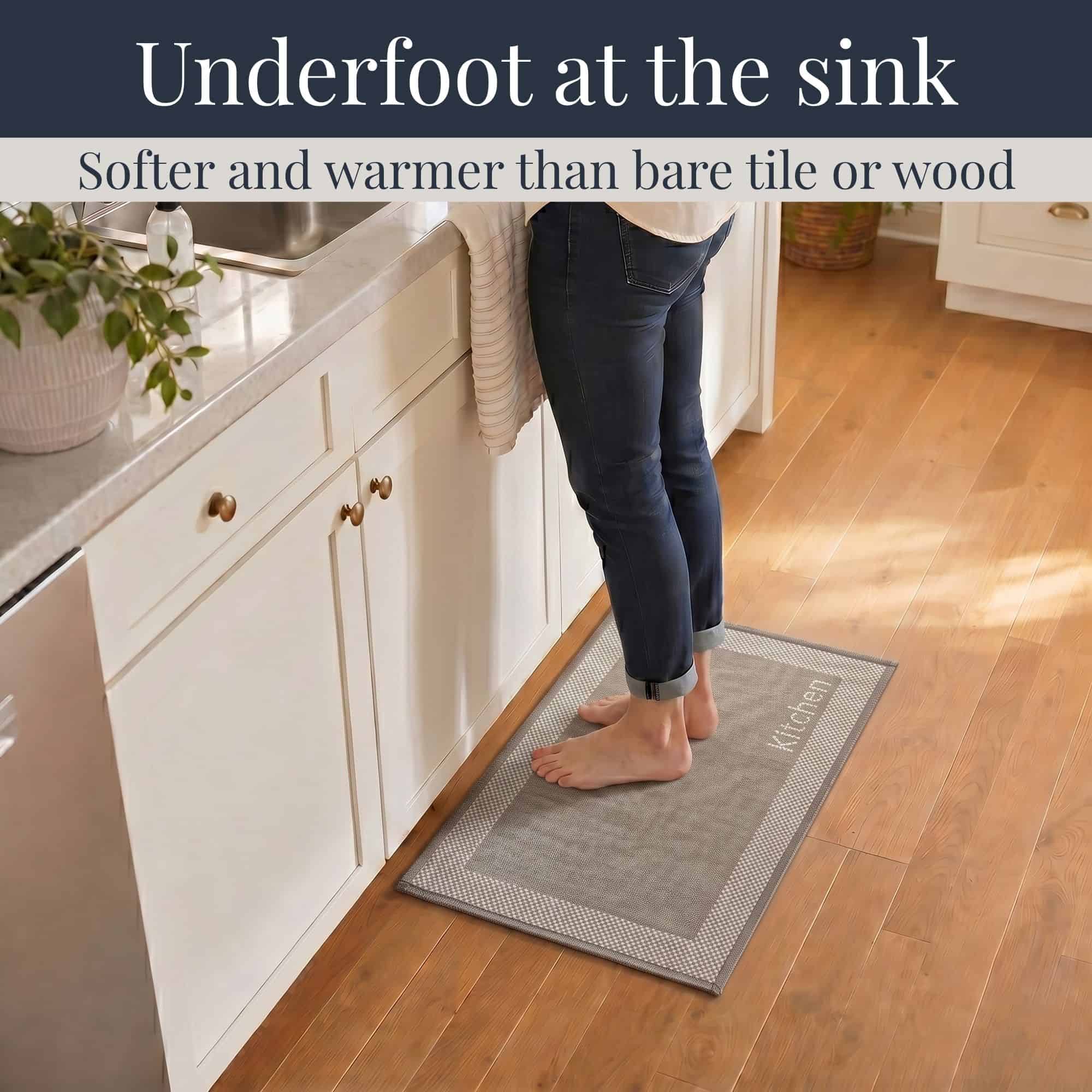 3- Barefoot person standing on taupe kitchen mat with cream border at the sink, cushioned on hardwood floor