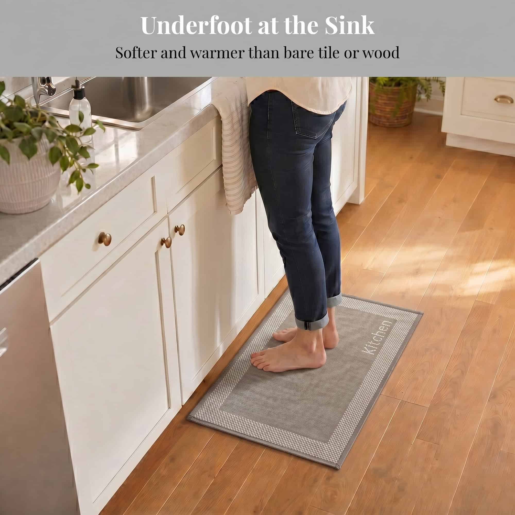 3- Barefoot person standing on taupe kitchen mat with cream border at the sink, cushioned on hardwood floor