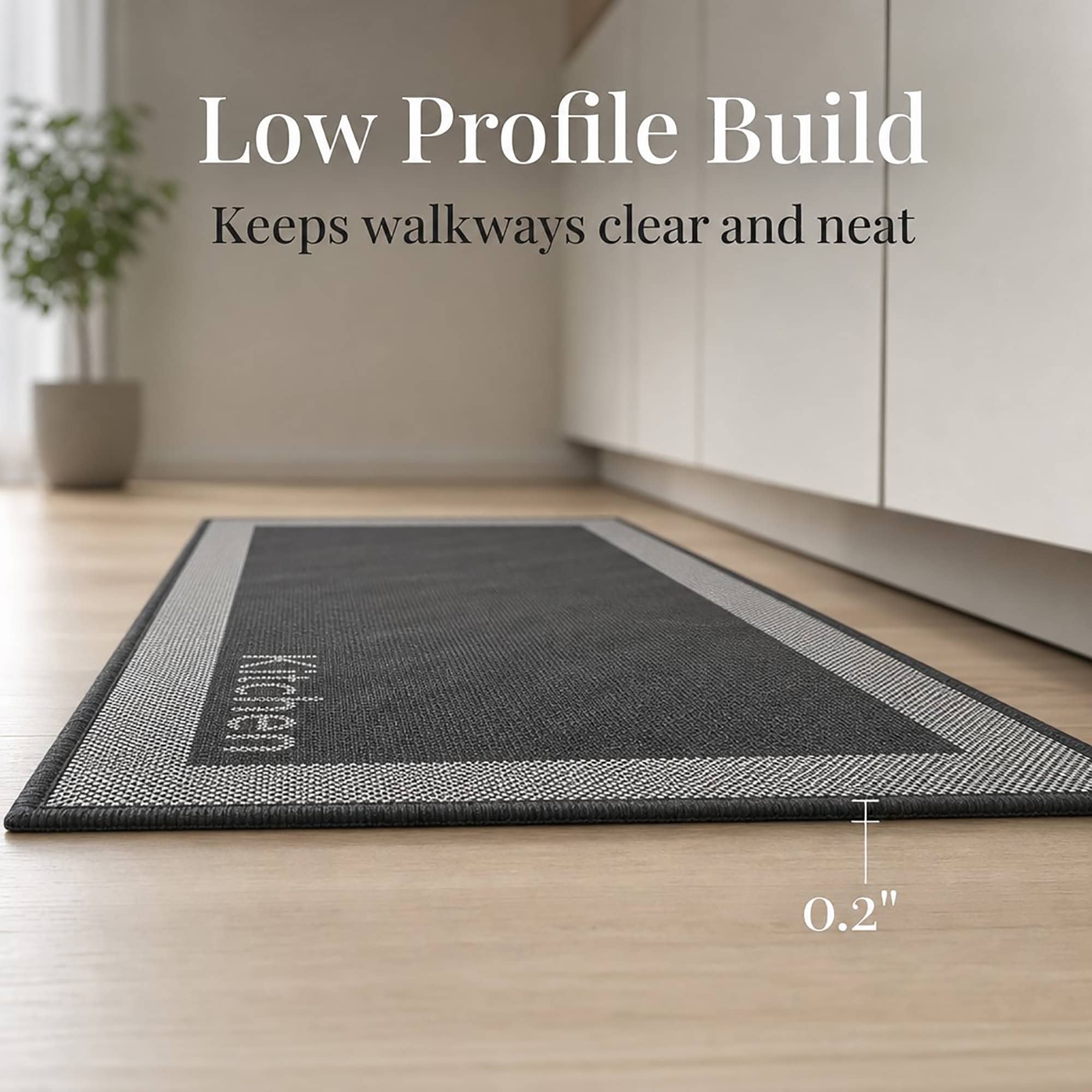 5- Low profile charcoal kitchen mat with cream border and woven Kitchen word, 0.2 inch thin, lying flat on wood floor