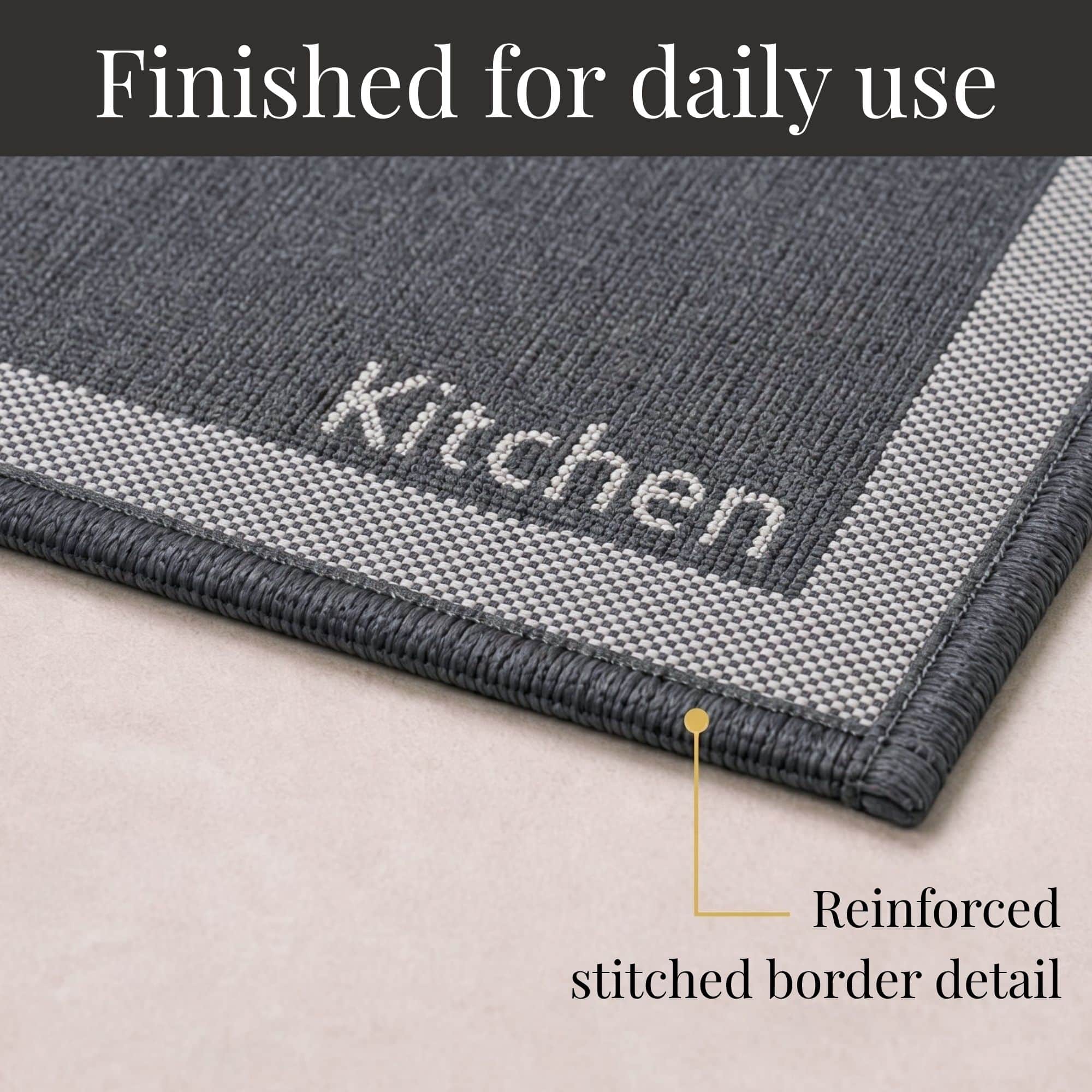 8- Close-up of charcoal kitchen mat corner with woven Kitchen word and reinforced stitched border detail