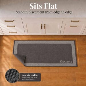 8- Charcoal and cream kitchen runner with Kitchen word lying flat, corner folded to show non slip backing on wood floor
