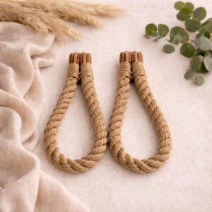 Natural jute twisted rope curtain tiebacks with wooden magnetic ends, laid flat on a white surface