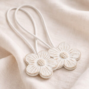 White carved resin flower curtain tiebacks with white cord on linen fabric