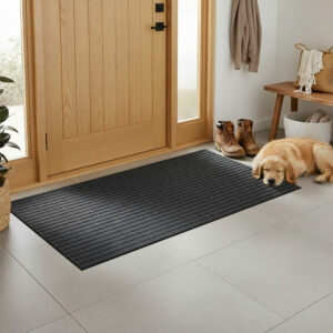 Entryway brushing doormat placed in front of a wooden door in a home entry