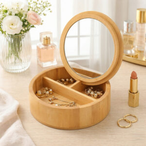 Open bamboo jewelry box with mirror lid displaying gold jewelry on a vanity