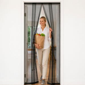 Woman walks hands free through strip fly screen door curtain carrying groceries – 4 fiberglass mesh strips – Evideco