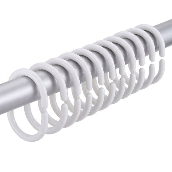 White plastic shower curtain hooks arranged on metal rod showing slim curved shape and smooth finish