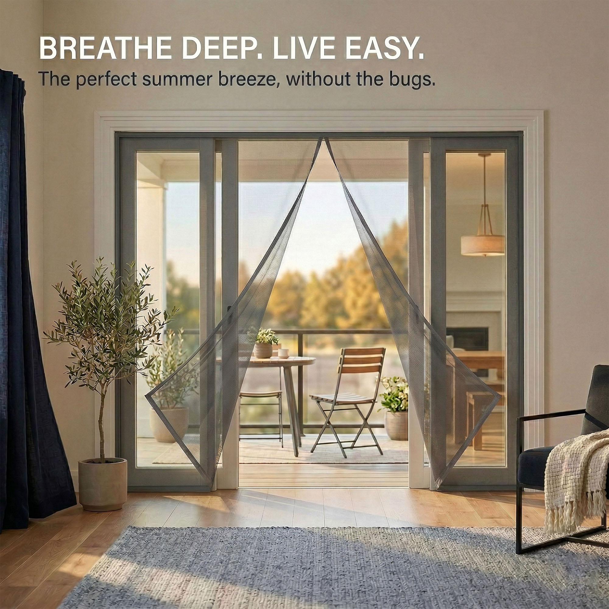 Evideco wide patio magnetic screen door with grey fiberglass mesh installed on sliding glass balcony door, living room interior with olive tree and armchair