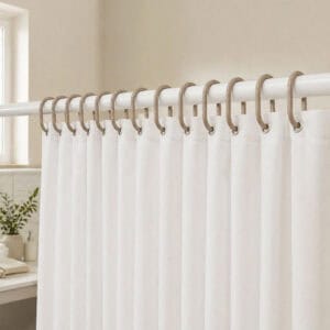 Light bathroom scene with neutral rings holding curtain in calming setup