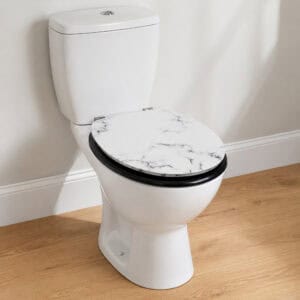 White marble elongated toilet seat with black edge and matte black trim mounted on a white toilet in a bright bathroom with wood flooring.